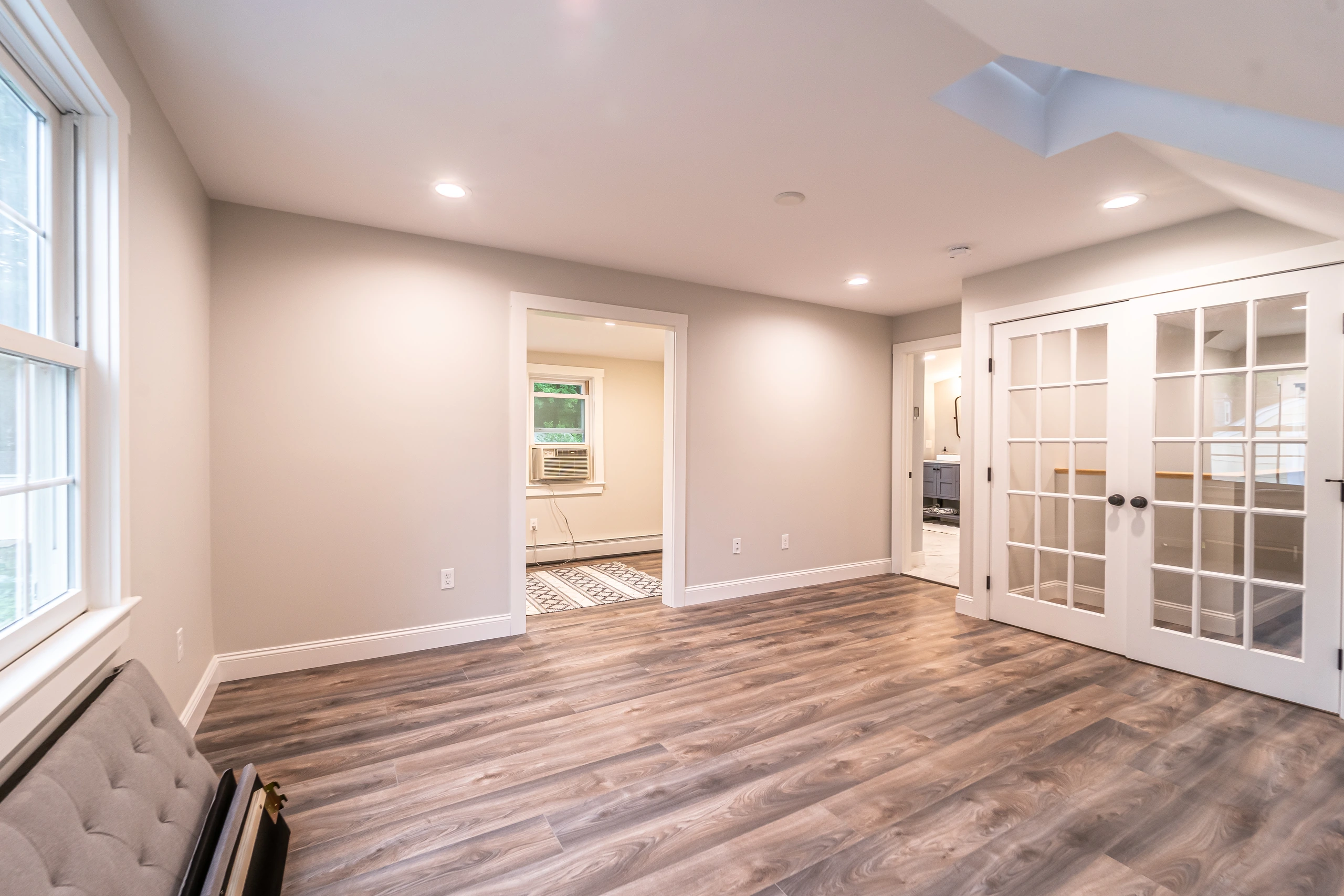 Finished attic room with recessed lights, French doors, and side nook, attic conversion in Framingham, MA