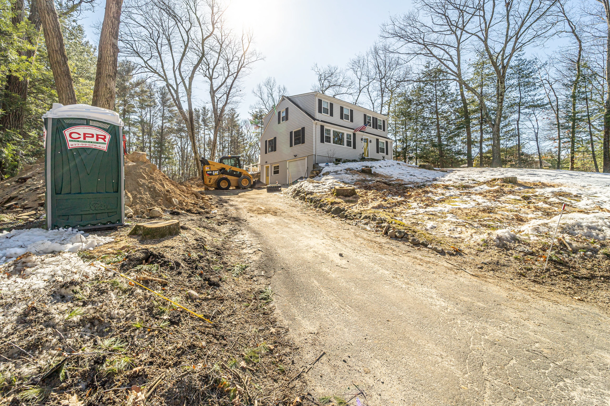 Gray colonial seen from the driveway before construction, home addition in Natick, MA
