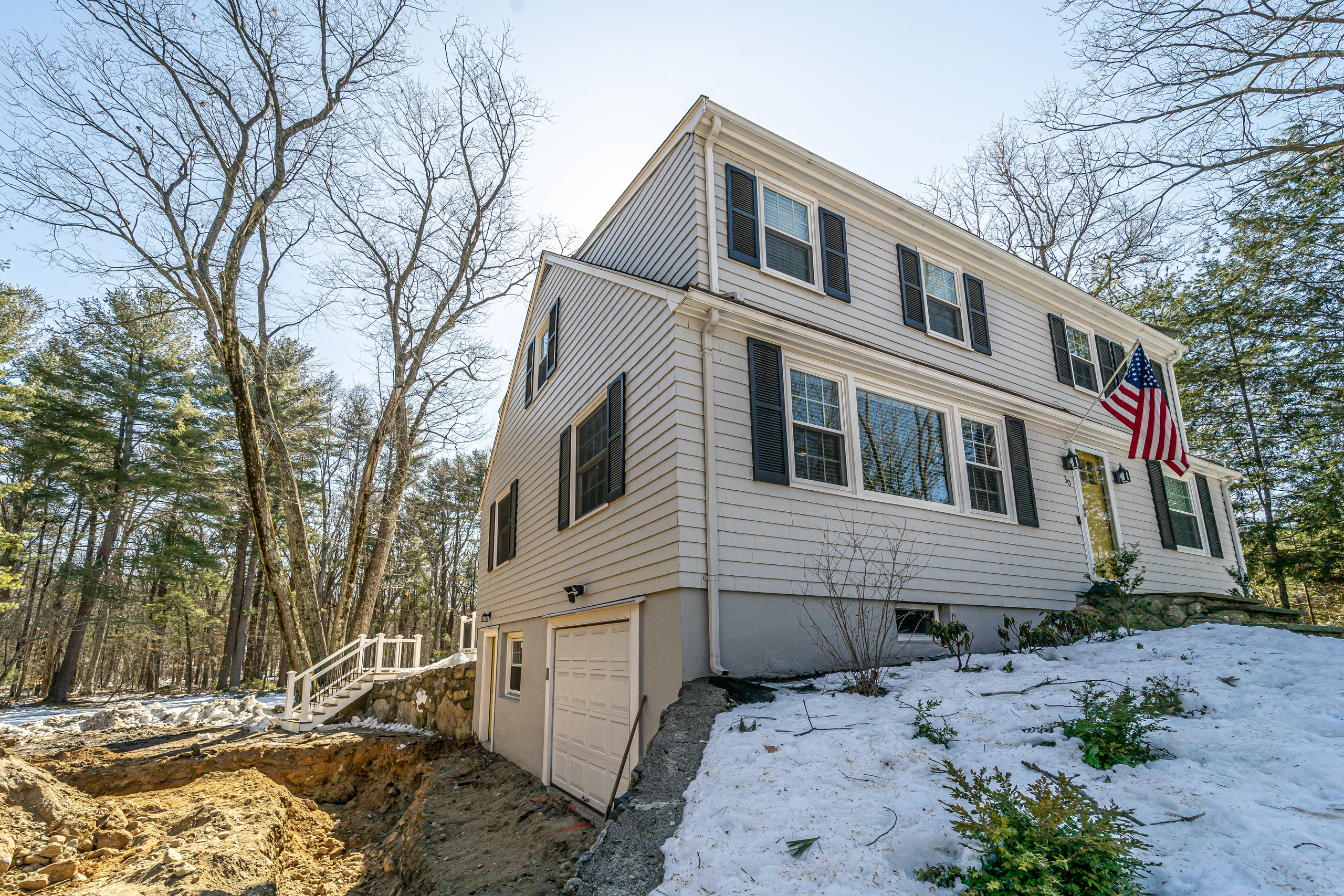 Front corner of the original gray colonial with excavation beginning at the side, home addition in Natick, MA
